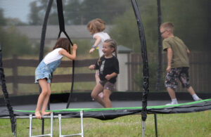 Czwórka dzieci skacze na trampolinie.